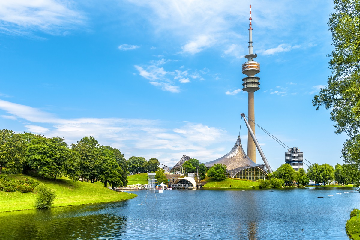 Munich Olympiapark in summer, Germany. It is the Olympic Park, landmark of Munich. Scenic view of former sport district. Scenery of Munich with tower and lake. Beautiful landscape of Munich city.