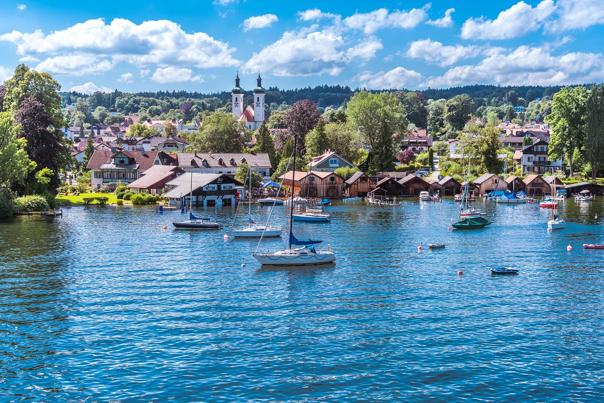 Tutzing am Starnberger See unter weiß-blauem Himmel und Segelyachten in der Bucht
