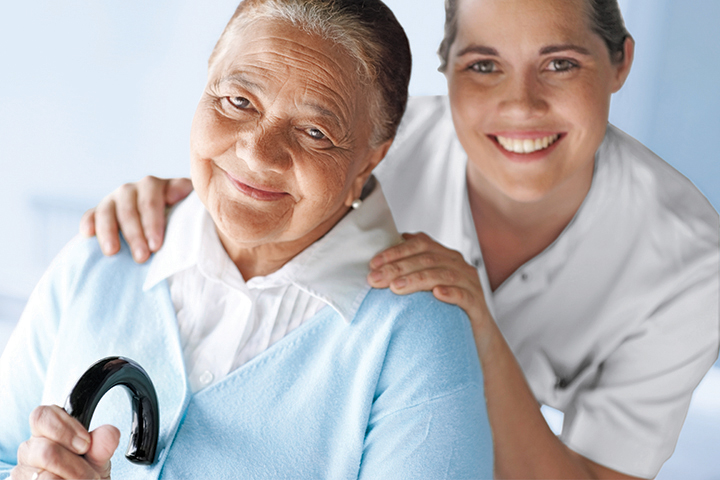 Happy elderly woman with a nurse smiling together