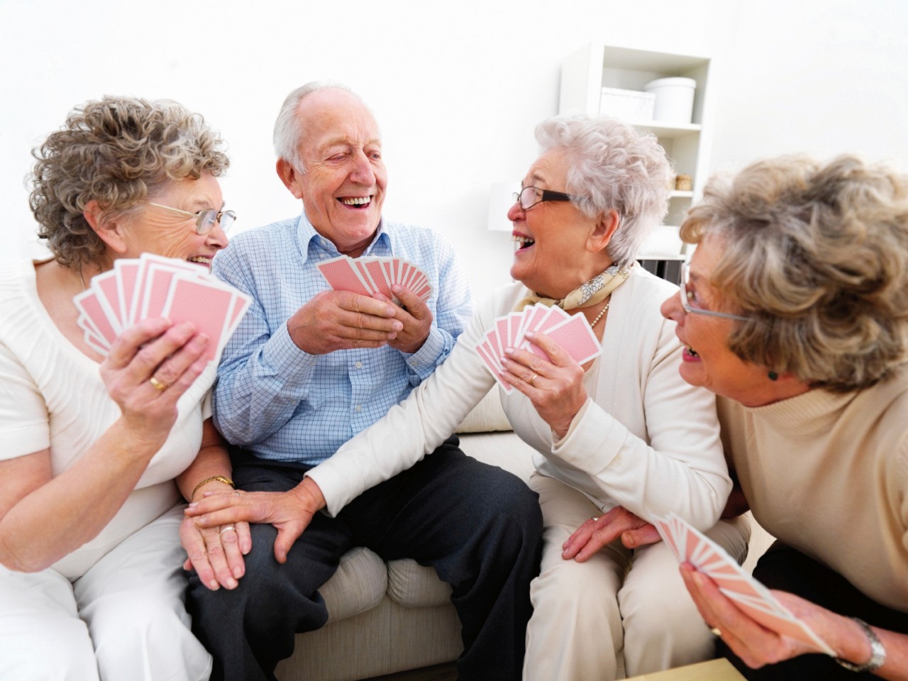 A group of happy elderly people enjoying themselves over a card game